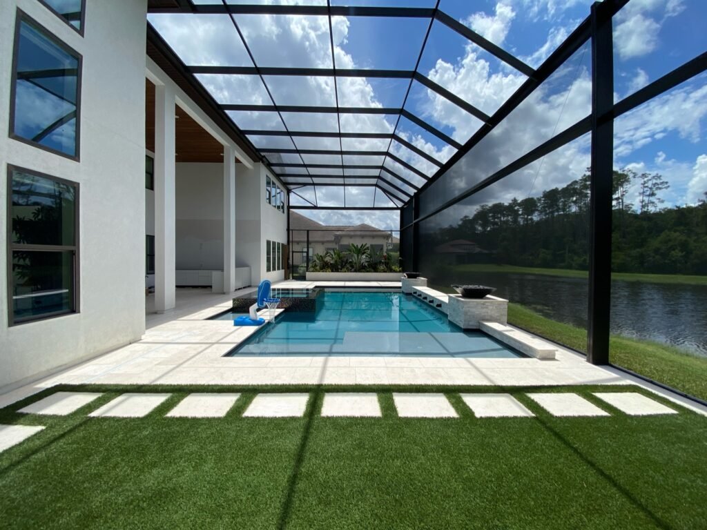 Modern pool screen enclosure in Spring Hill, FL overlooking backyard pool and lake view